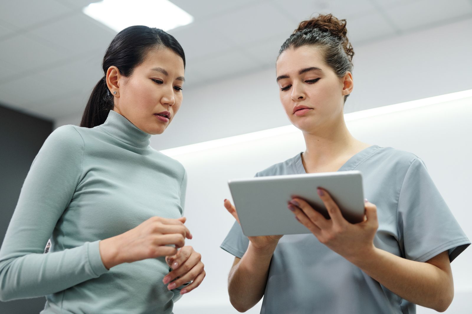 Healthcare professional and adult patient discussing a tablet